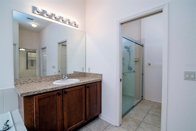 bathroom featuring a shower with door, vanity, and tile patterned flooring