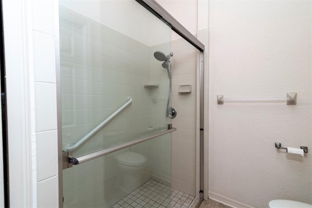 bathroom featuring an enclosed shower and toilet