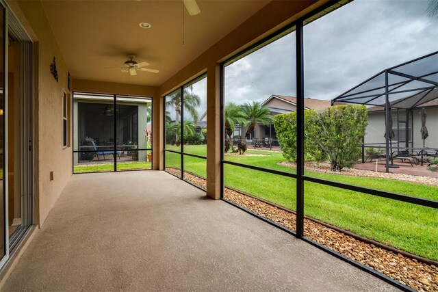 unfurnished sunroom with ceiling fan