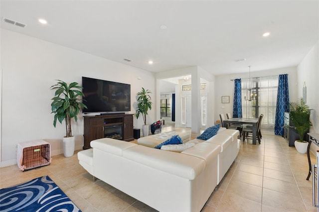 tiled living room featuring a chandelier