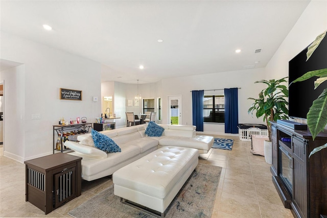 living room with a notable chandelier, light tile patterned floors, and sink