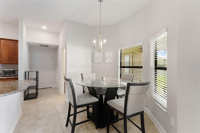 dining area with light tile patterned floors and an inviting chandelier