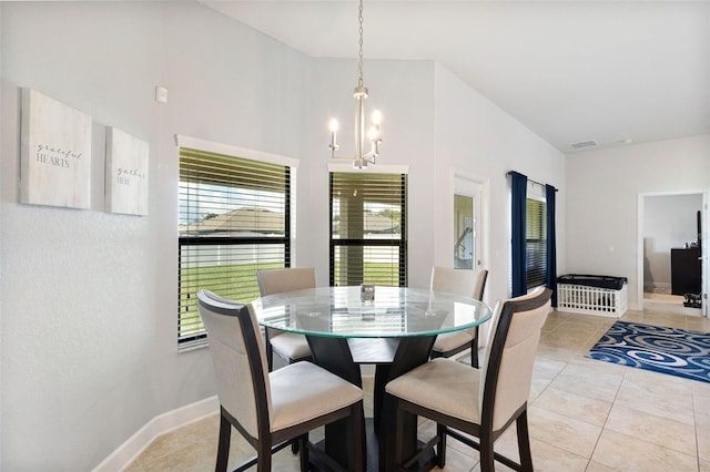 dining area with light tile patterned floors and an inviting chandelier