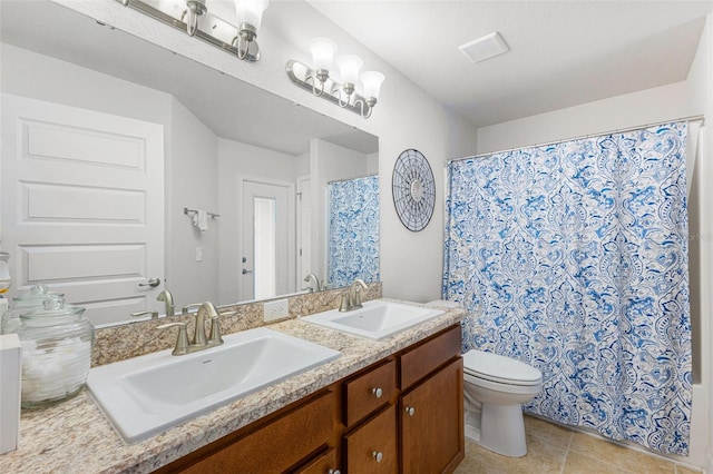 bathroom featuring tile patterned floors, vanity, and toilet