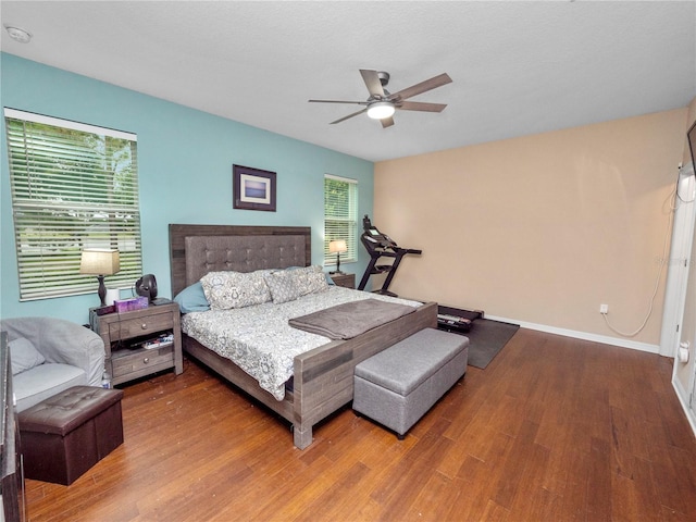 bedroom featuring ceiling fan, wood finished floors, and baseboards