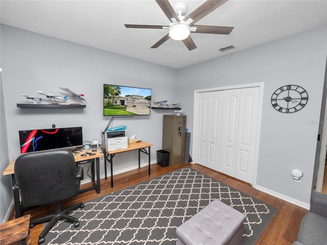 office area with wood finished floors, visible vents, and baseboards