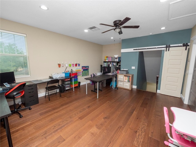 office space with a barn door, visible vents, ceiling fan, wood finished floors, and recessed lighting