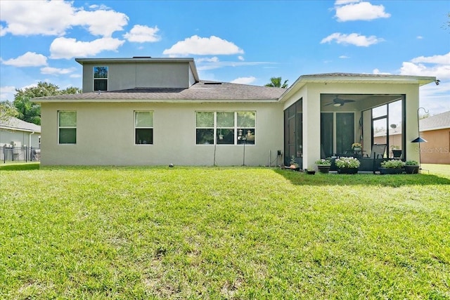 back of house with a sunroom, stucco siding, a ceiling fan, and a yard