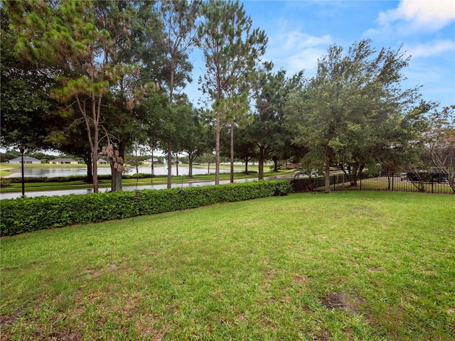 view of yard featuring a water view and fence