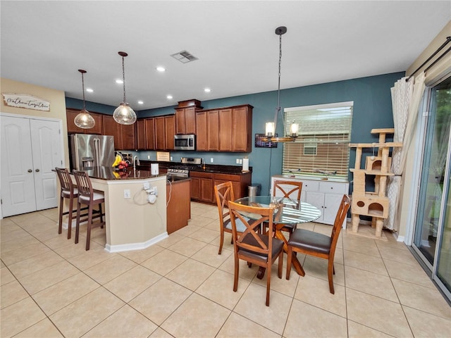 kitchen featuring stainless steel appliances, dark countertops, visible vents, and light tile patterned flooring