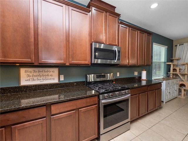 kitchen with light tile patterned floors, appliances with stainless steel finishes, dark stone countertops, and recessed lighting