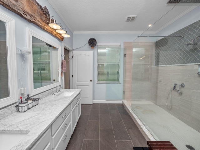 full bathroom with double vanity, visible vents, ornamental molding, a sink, and tiled shower