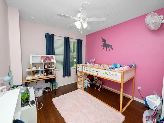 bedroom with a textured ceiling, baseboards, and wood finished floors