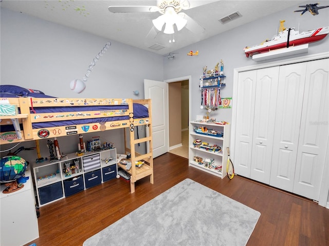 bedroom featuring a ceiling fan, a closet, visible vents, and wood finished floors