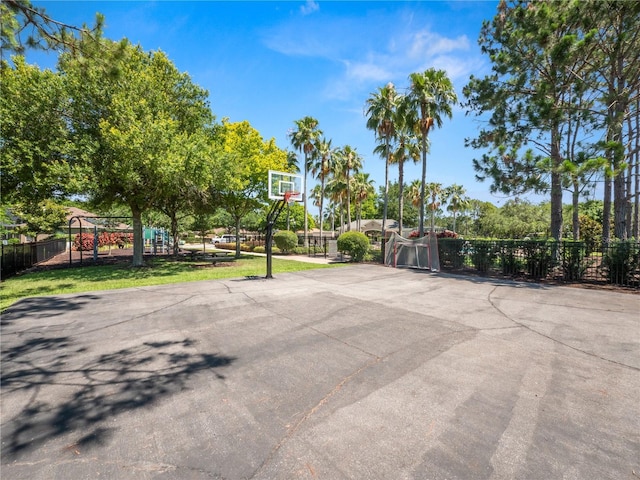 view of basketball court with playground community, community basketball court, and fence