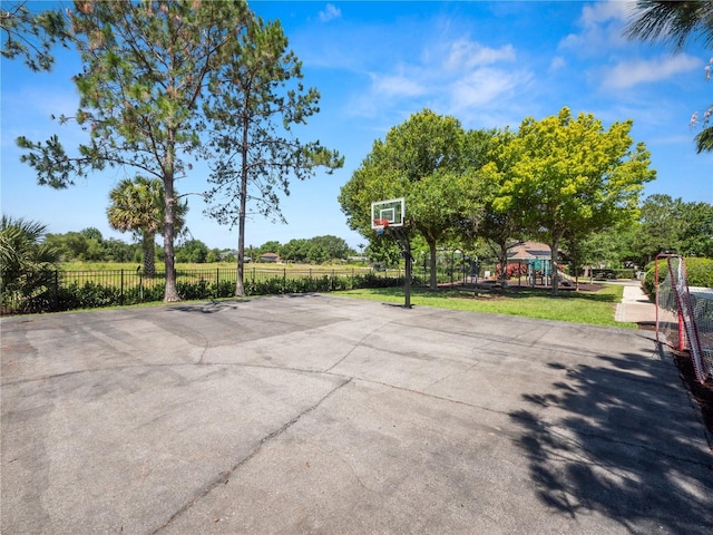 view of sport court with community basketball court, playground community, and fence