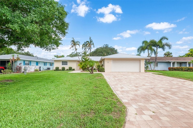 ranch-style home featuring a garage and a front lawn