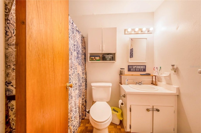 bathroom featuring oversized vanity, toilet, and parquet flooring