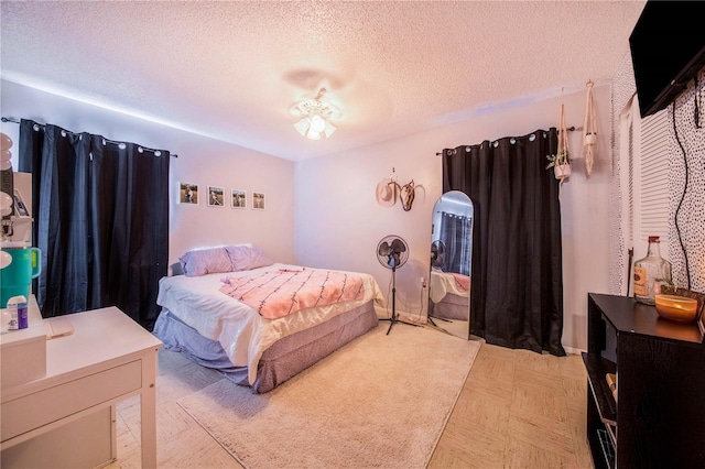 bedroom featuring ceiling fan and a textured ceiling