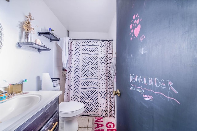 bathroom with tile flooring, vanity, and toilet