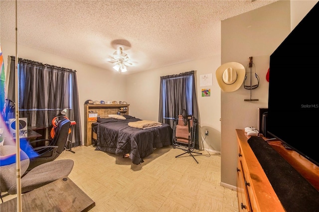 bedroom featuring ceiling fan and a textured ceiling