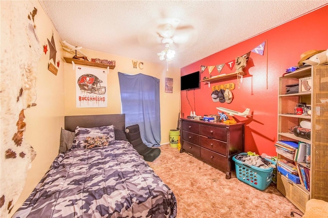 carpeted bedroom featuring ceiling fan and a textured ceiling