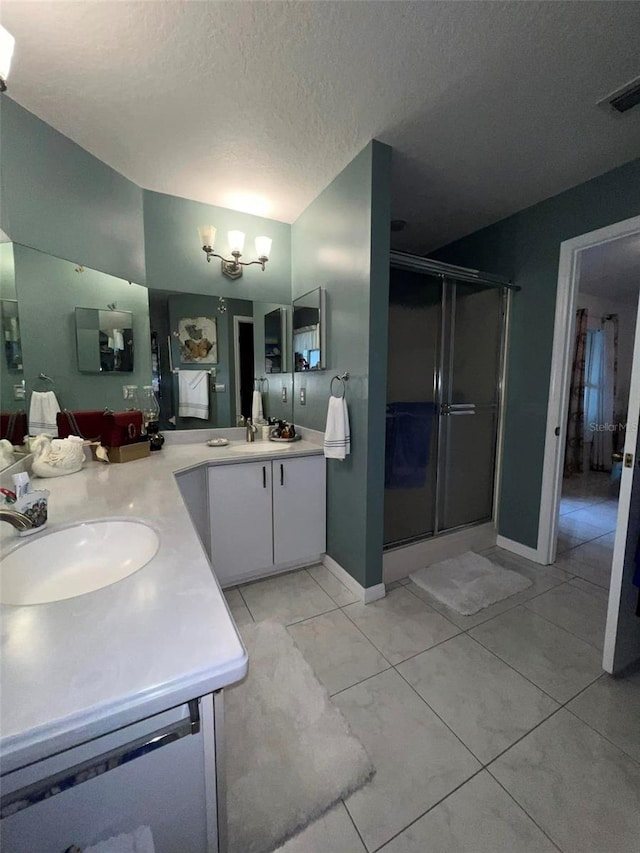 bathroom with a textured ceiling, vanity, a chandelier, and an enclosed shower