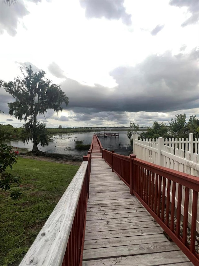 dock area with a lawn and a water view