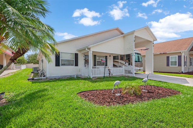 view of front facade featuring a front yard, central air condition unit, a carport, and covered porch