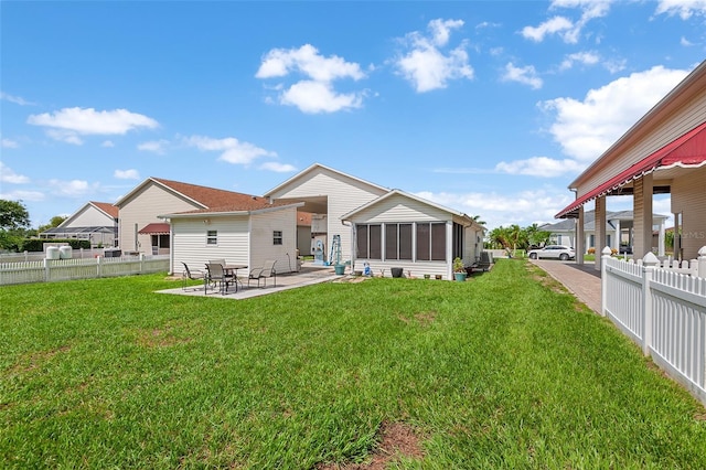 back of property featuring a sunroom, a yard, and a patio