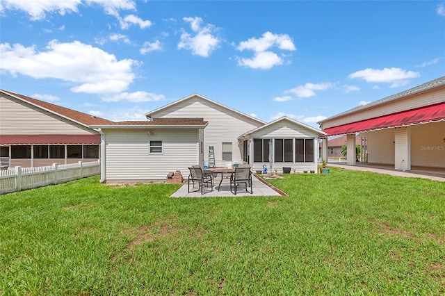 rear view of house with a patio area, a sunroom, and a yard