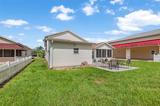 rear view of property with a patio and a lawn