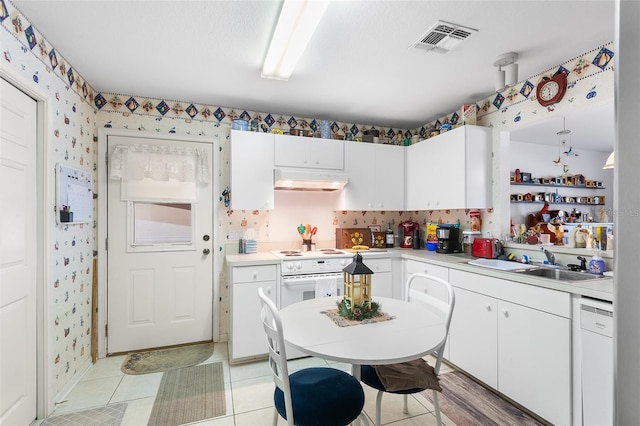 kitchen featuring white cabinetry, sink, light tile patterned floors, and white appliances