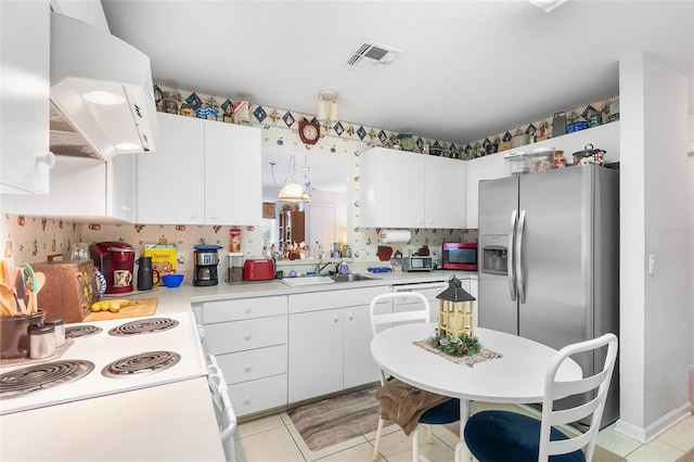 kitchen with stainless steel refrigerator with ice dispenser, stove, and white cabinetry