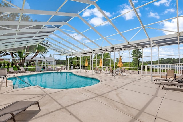 view of swimming pool featuring a patio and a lanai