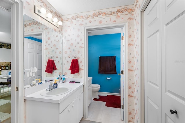 bathroom with baseboards, vanity, toilet, and wallpapered walls