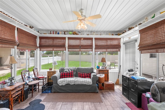 sunroom with ceiling fan, wooden ceiling, and a wealth of natural light