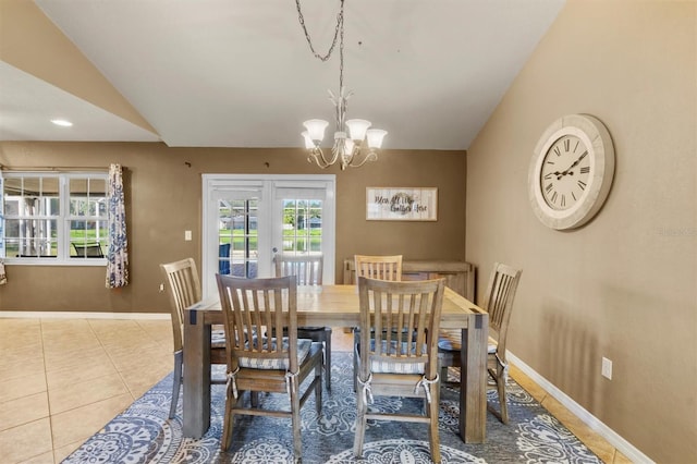 tiled dining room featuring a notable chandelier and vaulted ceiling