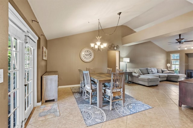 tiled dining area featuring lofted ceiling and ceiling fan with notable chandelier