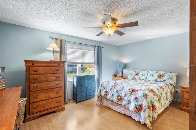 bedroom featuring light hardwood / wood-style floors, a textured ceiling, and ceiling fan