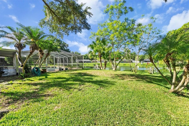 view of yard featuring a lanai and a water view