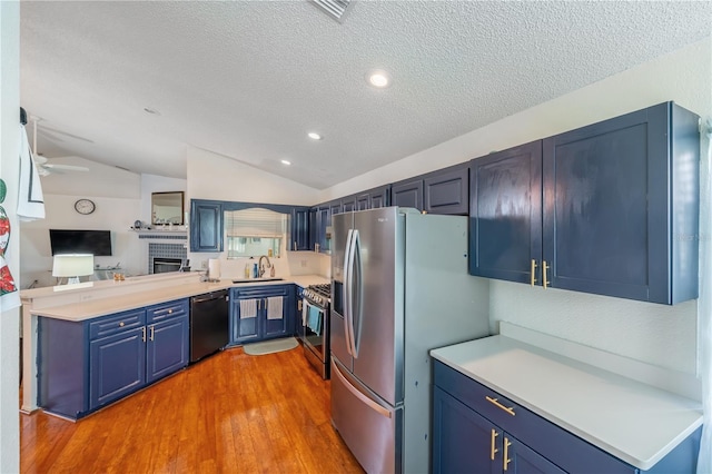 kitchen featuring appliances with stainless steel finishes, sink, lofted ceiling, and a textured ceiling