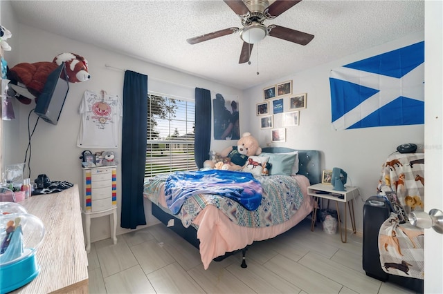 bedroom with ceiling fan and a textured ceiling