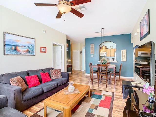 living room with light hardwood / wood-style floors and ceiling fan