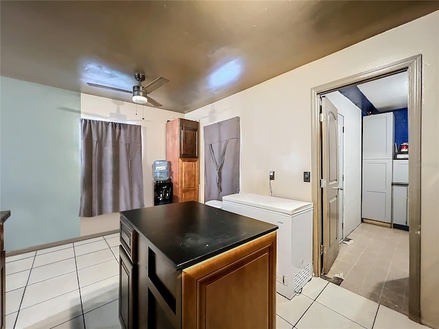 kitchen with light tile patterned flooring, a kitchen island, ceiling fan, and fridge