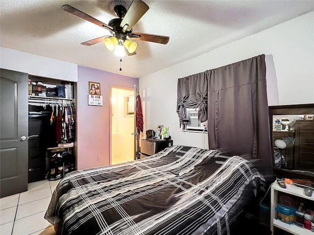 tiled bedroom featuring a textured ceiling, cooling unit, a closet, and ceiling fan