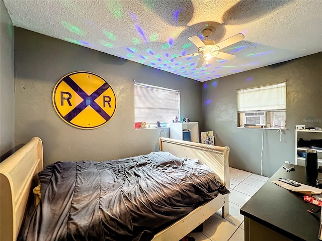 tiled bedroom featuring cooling unit, a textured ceiling, and ceiling fan