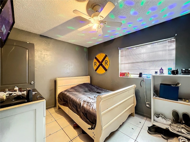 bedroom with light tile patterned flooring, a textured ceiling, and ceiling fan