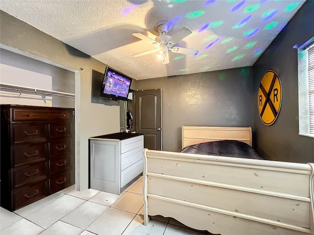 bedroom with light tile patterned flooring, a textured ceiling, and ceiling fan