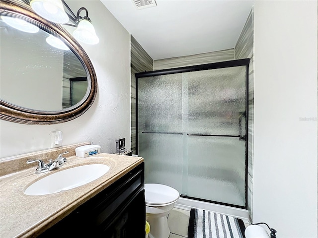 bathroom featuring vanity, an enclosed shower, tile patterned flooring, and toilet